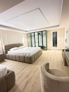 a large bedroom with a large bed and a chair at Old Town Inn room 8 in Pogradec