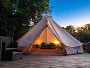 a white tent with a couch and chairs on a deck at Domaine du Fourtet in Arfons