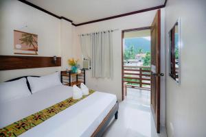 a bedroom with two beds and a balcony at Silverise Guest House in El Nido