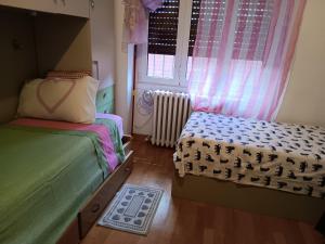 a small bedroom with two beds and a window at Casa Revello in Milan