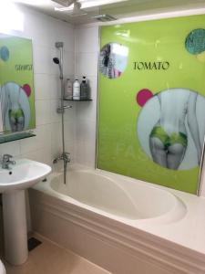 a bathroom with a bath tub and a sink at Tomato Hotel in Uijeongbu