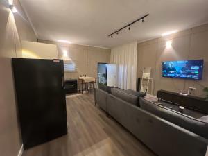 a living room with couches and a flat screen tv at בית הקונגרס גבעת אולגה in H̱adera