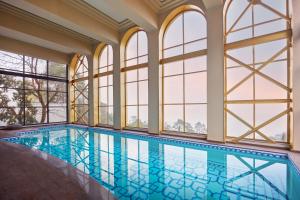 an indoor pool in a house with windows at Bhangeri Durbar Resort in Nagarkot