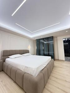 a large bed in a room with a large couch at Old Town Inn room 9 in Pogradec +1 photo