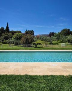 a swimming pool with blue water in a park at Tenuta Aronne in Massa Marittima