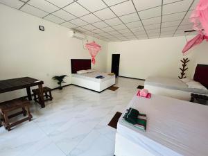 a living room with two beds and a piano at Hotel Mandara Udawalawe in Udawalawe +2 photos