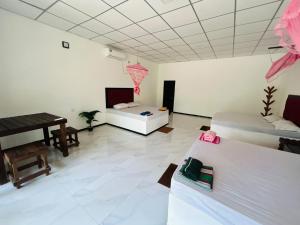 a living room with two beds and a piano at Hotel Mandara Udawalawe in Udawalawe