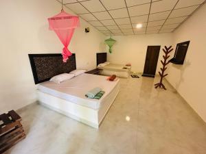 a room with a large bed in a room at Hotel Mandara Udawalawe in Udawalawe