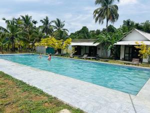 a family in the swimming pool of a villa at Hotel Mandara Udawalawe in Udawalawe