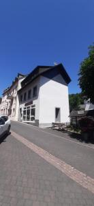 a white building on the side of a street at Herzstück Ferienwohnung Waxweiler in Waxweiler