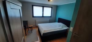 a small bedroom with a bed and a window at Herzstück Ferienwohnung Waxweiler in Waxweiler +7 photos