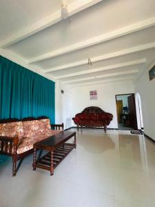 a living room with two couches and a table at OLA Villa in Mawella