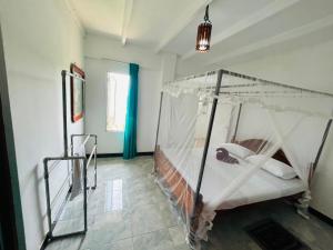 a bedroom with a canopy bed in a room at OLA Villa in Mawella