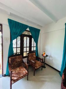 two chairs sitting in a room with a window at OLA Villa in Mawella