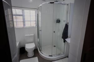 a white bathroom with a shower and a toilet at Serenity Cottage in Swellendam +55 photos