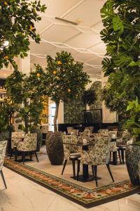 a restaurant with tables and chairs and citrus trees at HOTEL BALKAN in Bijeljina