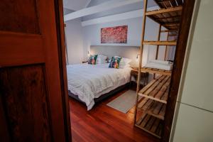 a bedroom with a bed and a bunk ladder at Serenity Cottage in Swellendam