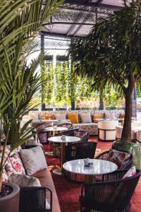 a restaurant with tables and chairs and plants at HOTEL BALKAN in Bijeljina