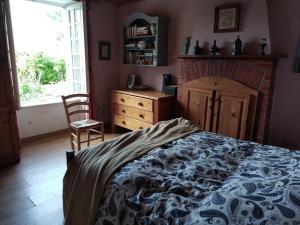 ein Schlafzimmer mit einem Bett, einer Kommode und einem Fenster in der Unterkunft Les Douitils in Saint-Sauveur-la-Pommeraye