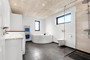 a white bathroom with a tub and a shower at 0431-Romo-Vestergade-333 in Høm +16 photos