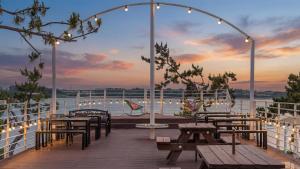 a deck with tables and benches on a cruise ship at Mu-an Prejong Dokchae Pension in Muan +7 photos