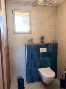 a bathroom with a toilet and a window at Le Chalet du Soleil Levant in Longevilles-Mont-dʼOr +5 photos