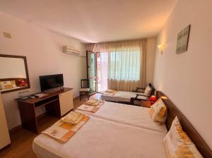 a hotel room with two beds and a television at Семеен Хотел Примо Family Hotel Primo in Primorsko