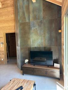 a living room with a flat screen tv on a wall at Le Chalet du Soleil Levant in Longevilles-Mont-dʼOr