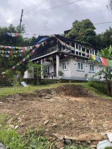 ein Haus mit Gebetsfahnen davor in der Unterkunft Hideaway Cottage in Pokhara