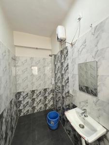 a bathroom with a sink and a blue bucket at Rajratna lodge in Lohogaon +19 photos