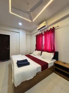a bedroom with a large bed with a red curtain at Rajratna lodge in Lohogaon