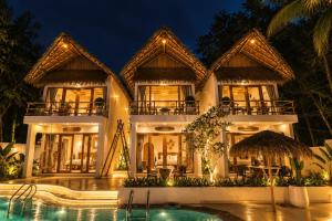 a villa with a swimming pool at night at Ayana Lake Resorts in Kovillūr