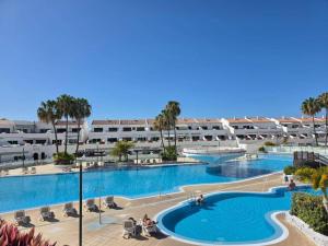 a large swimming pool in a resort with palm trees at Marys Place in Costa Del Silencio