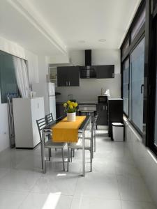 a kitchen with a table and chairs and a kitchen with black cabinets at Marys Place in Costa Del Silencio