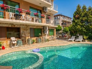 a swimming pool in front of a building at Семеен Хотел Примо Family Hotel Primo in Primorsko
