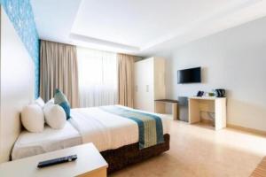 a hotel room with a bed and a desk at Toquee Hotel Bookings - Nairobi in Nairobi