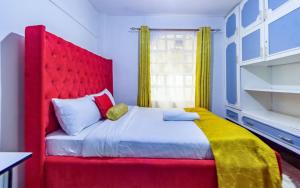 a bed with a red headboard in a room at Toquee Hotel Bookings - Nairobi in Nairobi