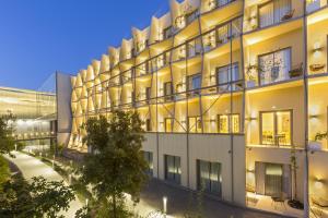an external view of a building at night at SOWELL HÔTELS Villa Arena in Nîmes