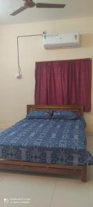 a bed in a room with a red curtain at Velli apartment in Tirunelveli