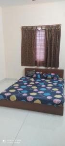 a bedroom with a bed with a colorful comforter at Velli apartment in Tirunelveli