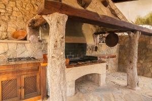 a stone kitchen with a stove and a stone wall at Can Xilla by Sealand Villas in Alcudia
