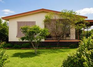 a house with a green yard in front of it at Manilla Cottage - Manilla NSW in Manilla