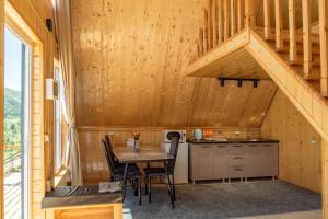 a dining room with a table and a staircase at A-frame Sky in Karakol