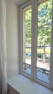 a white window with a view of a balcony at LOCAPONDI 5 - Les Reflets du Canal in Pontivy