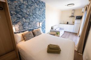 a bedroom with a bed with a blue wall at La Casa Contenedor Loft in Zaragoza