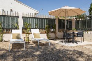 a patio with a table and chairs and an umbrella at La Casa Contenedor Loft in Zaragoza