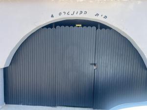 a large metal garage door in a building at בית הקונגרס גבעת אולגה in H̱adera