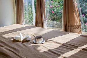 a book and a cup of coffee on a bed at Bhimtaal cottages in Bhīm Tāl