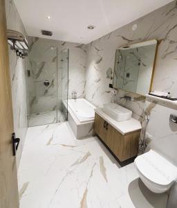 a bathroom with a sink and a toilet and a shower at The Chinmaye Grand in Bhāgalpur