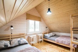 a bedroom with two beds in a wooden cabin at Przystanek Rydzówka - domki na Mazurach in Srokowo